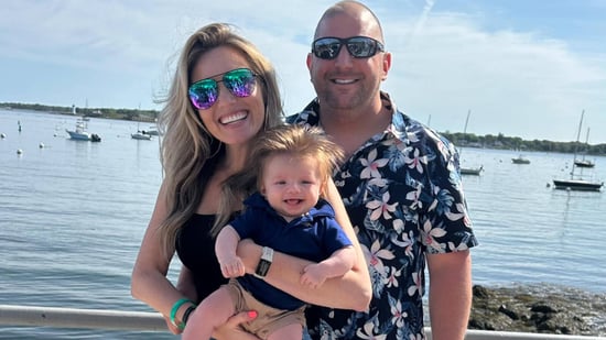 mom dad and baby standing outside in front of harbor wearing sunglasses