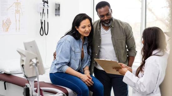 a couple in a doctor's exam room listening to them explain ivf process