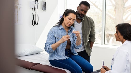 couple in exam room with doctor learning how to inject ivf medications