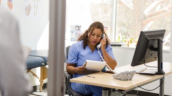 fertility nurse sitting at desk on phone telling patient test results