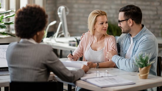 happy couple signing contract at surrogacy agency with attorney