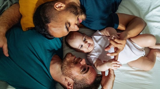 gay couple laying on floor with baby