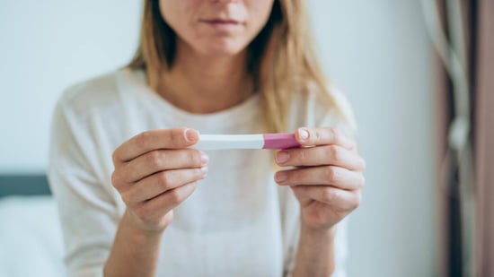 woman looking at a pregnancy test