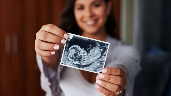 surrogate holding ultrasound picture smiling