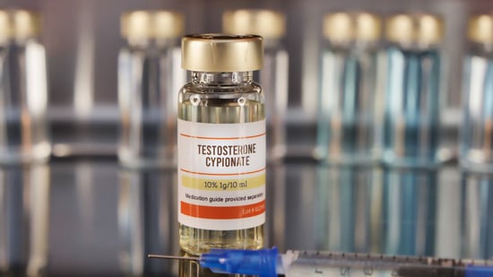 a vial of testosterone in the foreground with additional vials in background