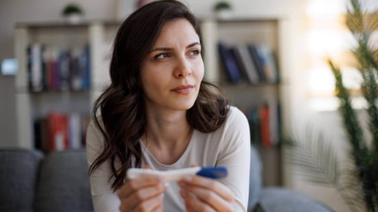 concerned woman holding negative pregnancy test