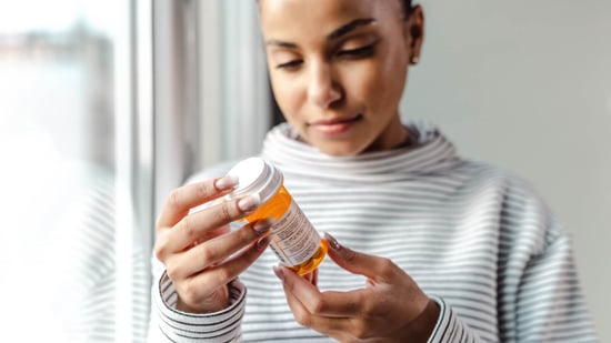 woman holding orange prescription bottle for ovulation induction medications